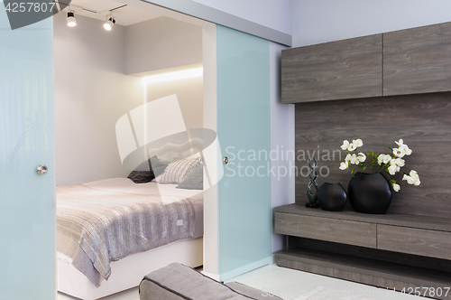 Image of Modern white living studio with bedroom doors open