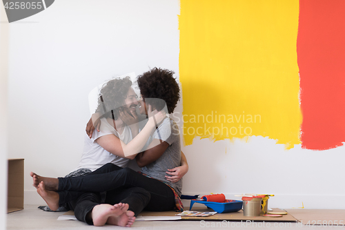 Image of young multiethnic couple relaxing after painting