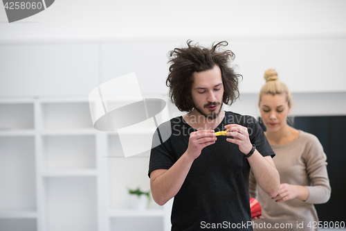 Image of couple in party hats blowing in whistle