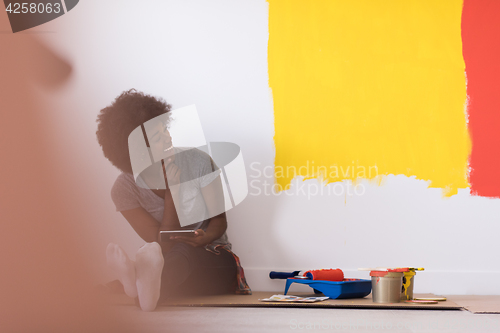 Image of back female painter sitting on floor