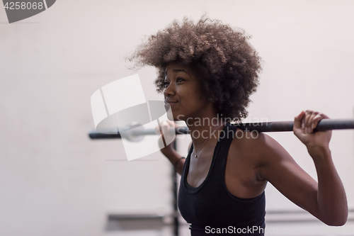 Image of black woman lifting empty bar