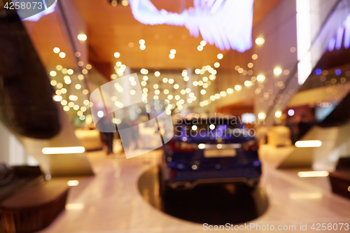 Image of Blurred, defocused background of public event exhibition hall showing cars and automobiles