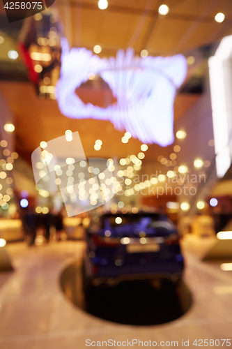 Image of Blurred, defocused background of public event exhibition hall showing cars and automobiles