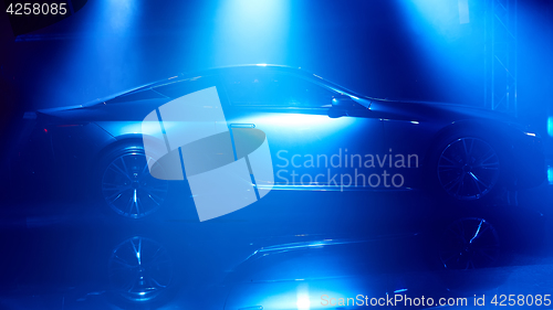 Image of Silhouette of car with headlights on black background.