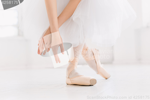 Image of Young ballerina dancing, closeup on legs and shoes, standing in pointe position.