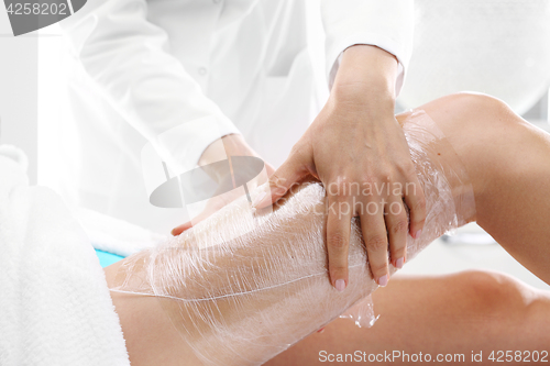 Image of Beautician woman&#39;s body wrapped with foil