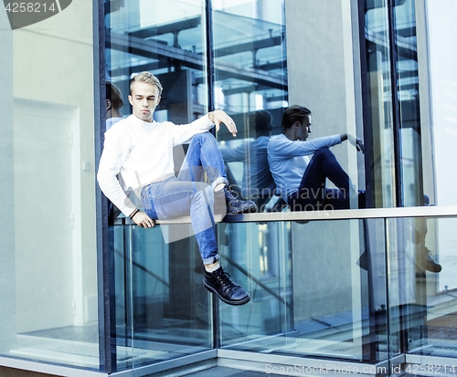 Image of young modern hipster guy at new building university blond fashion hairstyle having fun, lifestyle people concept 