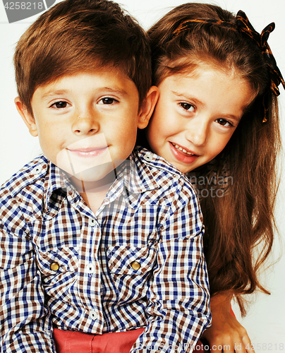 Image of little cute boy and girl hugging playing on white background, ha