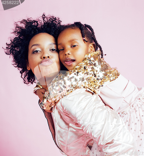 Image of young pretty african-american mother with little cute daughter hugging, happy smiling on pink background, lifestyle modern people concept 