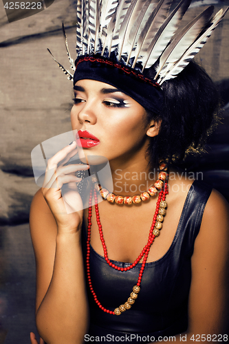 Image of young pretty woman with make up like red indian, futher in hair,