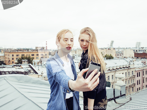 Image of two cool blond real girls friends making selfie on roof top, lifestyle people concept, modern teens