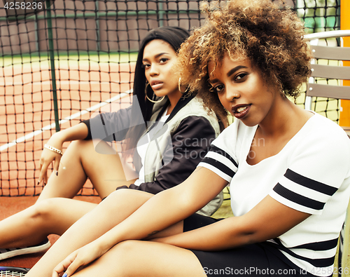 Image of young pretty girlfriends hanging on tennis court, fashion stylis