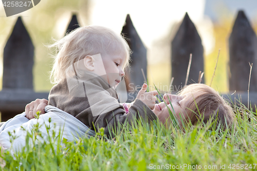 Image of woman plays with baby