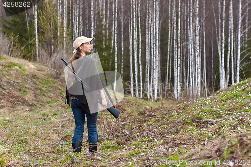 Image of Woman hunter with gun in forest