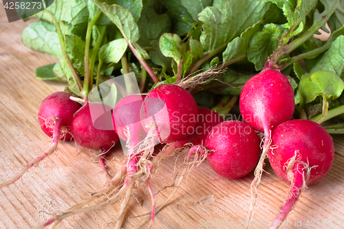 Image of bunch of fresh radishes on the wooden table