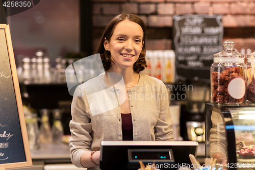 Image of happy woman or barmaid with cashbox at cafe