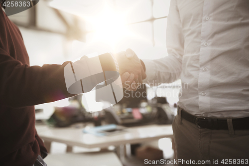 Image of businessmen making handshake at office