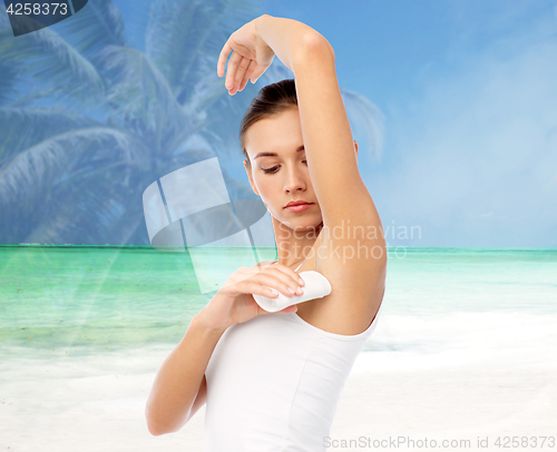 Image of woman with antiperspirant deodorant over beach