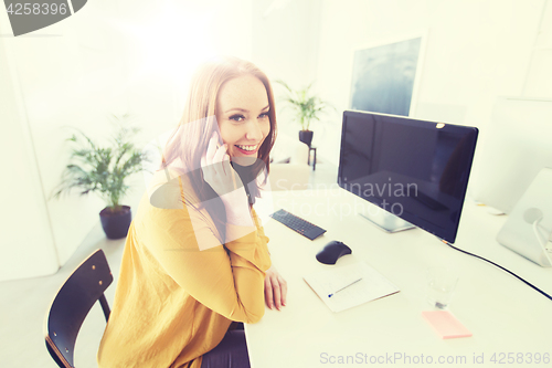 Image of businesswoman calling on smartphone at office