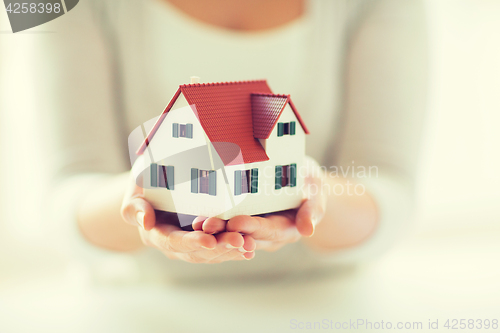 Image of close up of hands holding house or home model