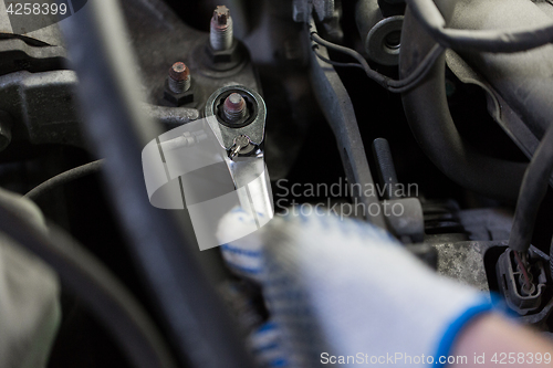 Image of mechanic man with wrench repairing car at workshop