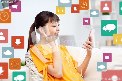 Image of happy asian woman with smartphone and earphones