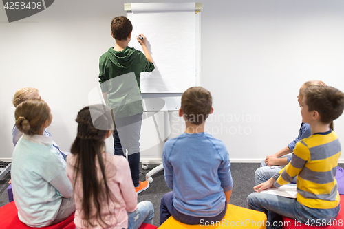 Image of student boy with marker writing on flip board