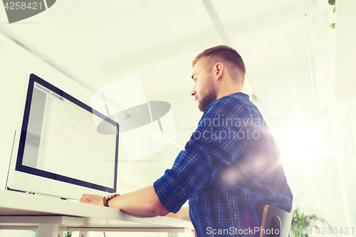 Image of creative man or programmer with computer at office