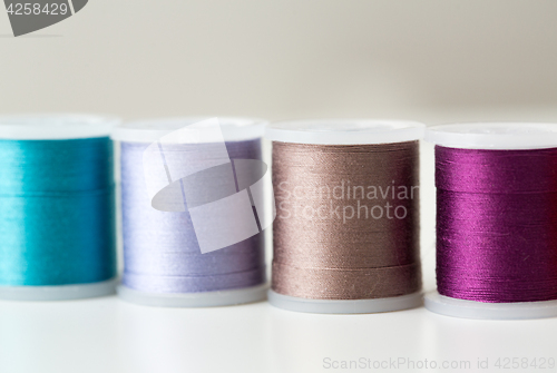 Image of row of colorful thread spools on table