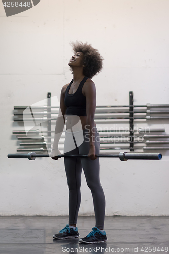 Image of black woman lifting empty bar