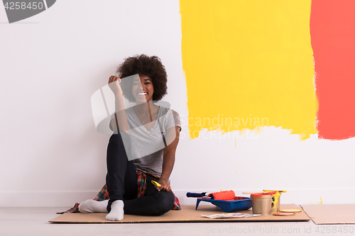 Image of back female painter sitting on floor