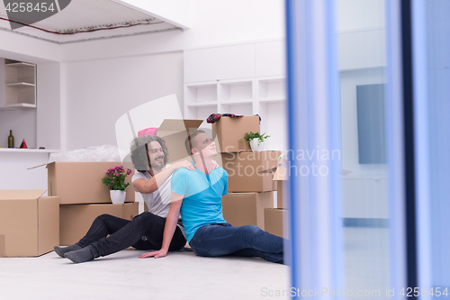 Image of young  gay couple moving  in new house