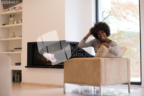 Image of black woman in front of fireplace