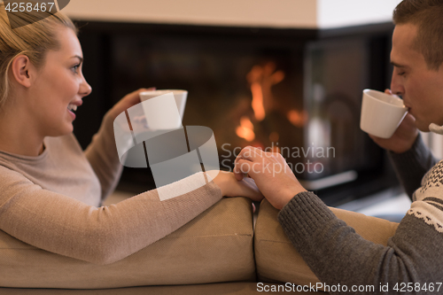 Image of Young couple  in front of fireplace