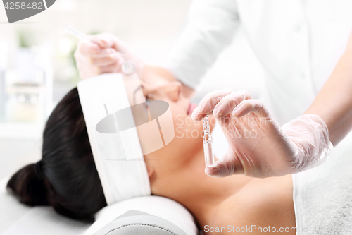 Image of Vitamin cocktail in an ampoule, a woman in the beauty salon