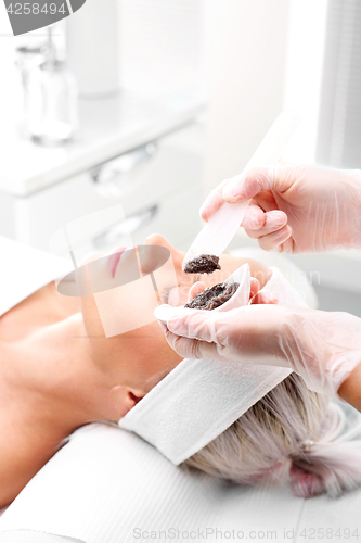 Image of Sugar peeling, treatment in the beauty salon. Cleansing mask, a woman in the beauty salon.