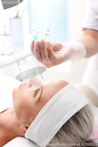 Image of Vitamin cocktail in an ampoule, a woman in the beauty salon