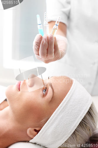 Image of Hand beauticians shows an ampoule with a cosmetic preparation