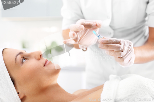 Image of Hand beauticians shows an ampoule with a cosmetic preparation