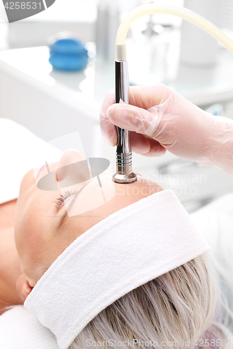 Image of Relaxed woman during a microdermabrasion treatment in beauty salon