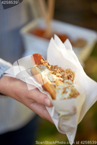 Image of close up of hand with hot dog