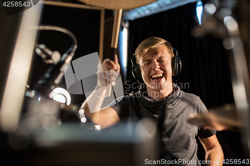 Image of male musician playing drums and cymbals at concert