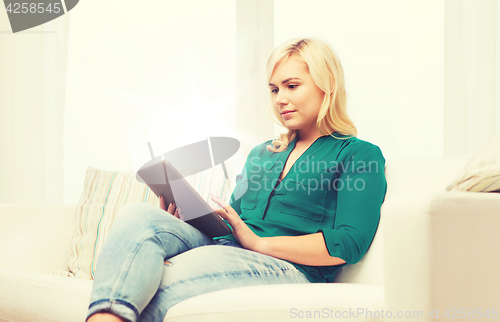 Image of smiling woman with tablet pc at home