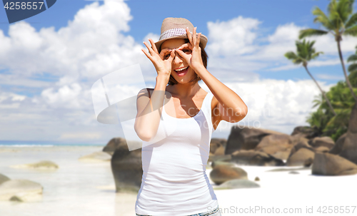 Image of happy young woman in hat on summer beach