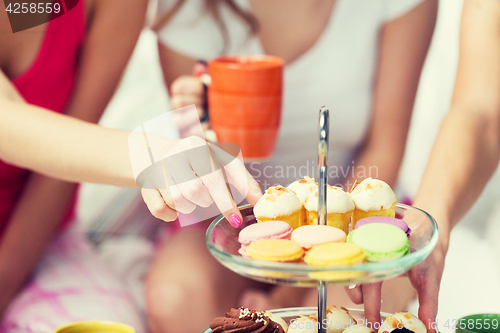 Image of friends or teen girls eating sweets at home