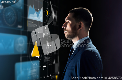 Image of businessman in suit looking at virtual projection