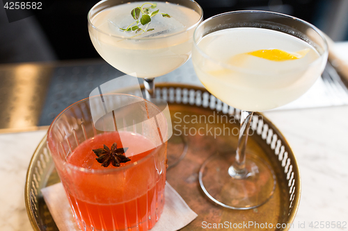 Image of tray with glasses of cocktails at bar