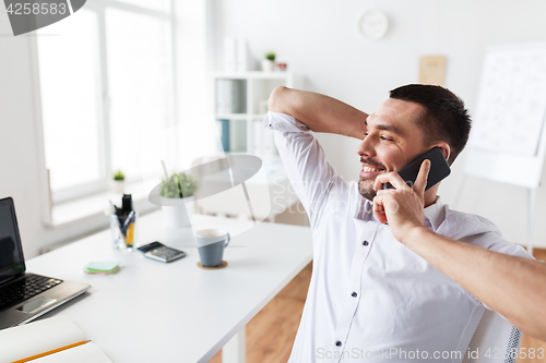 Image of businessman calling on smartphone at office