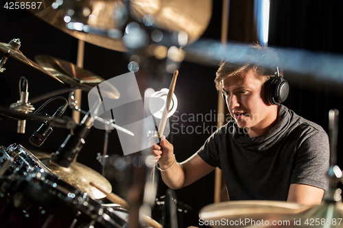 Image of male musician playing drums and cymbals at concert