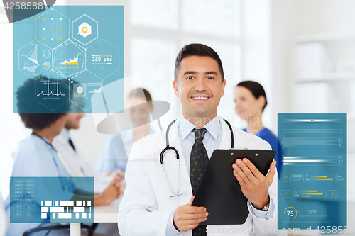 Image of happy doctor with clipboard over medical team